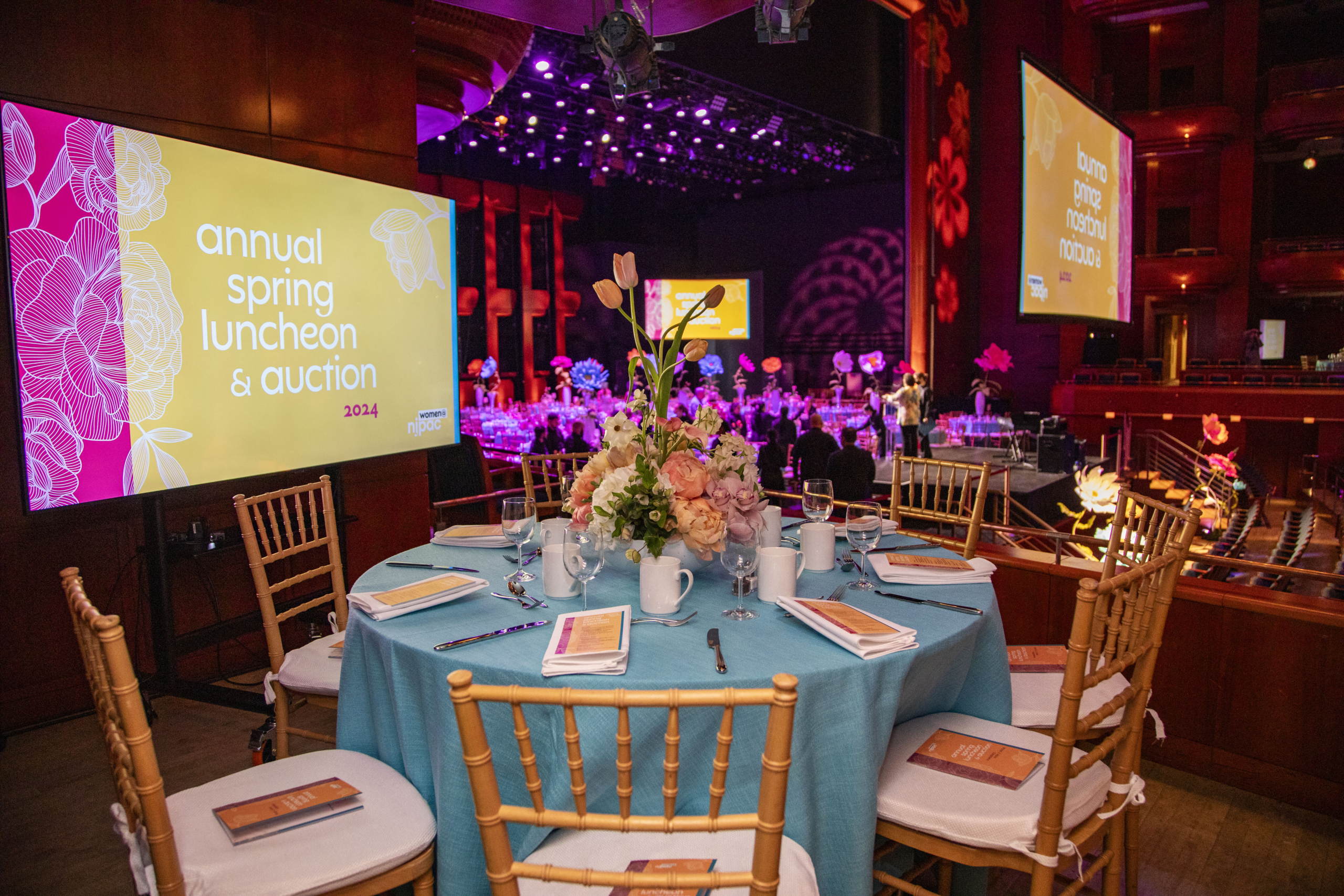 a dressed up table with nice place settings and six seats around overlooks the njpac stage